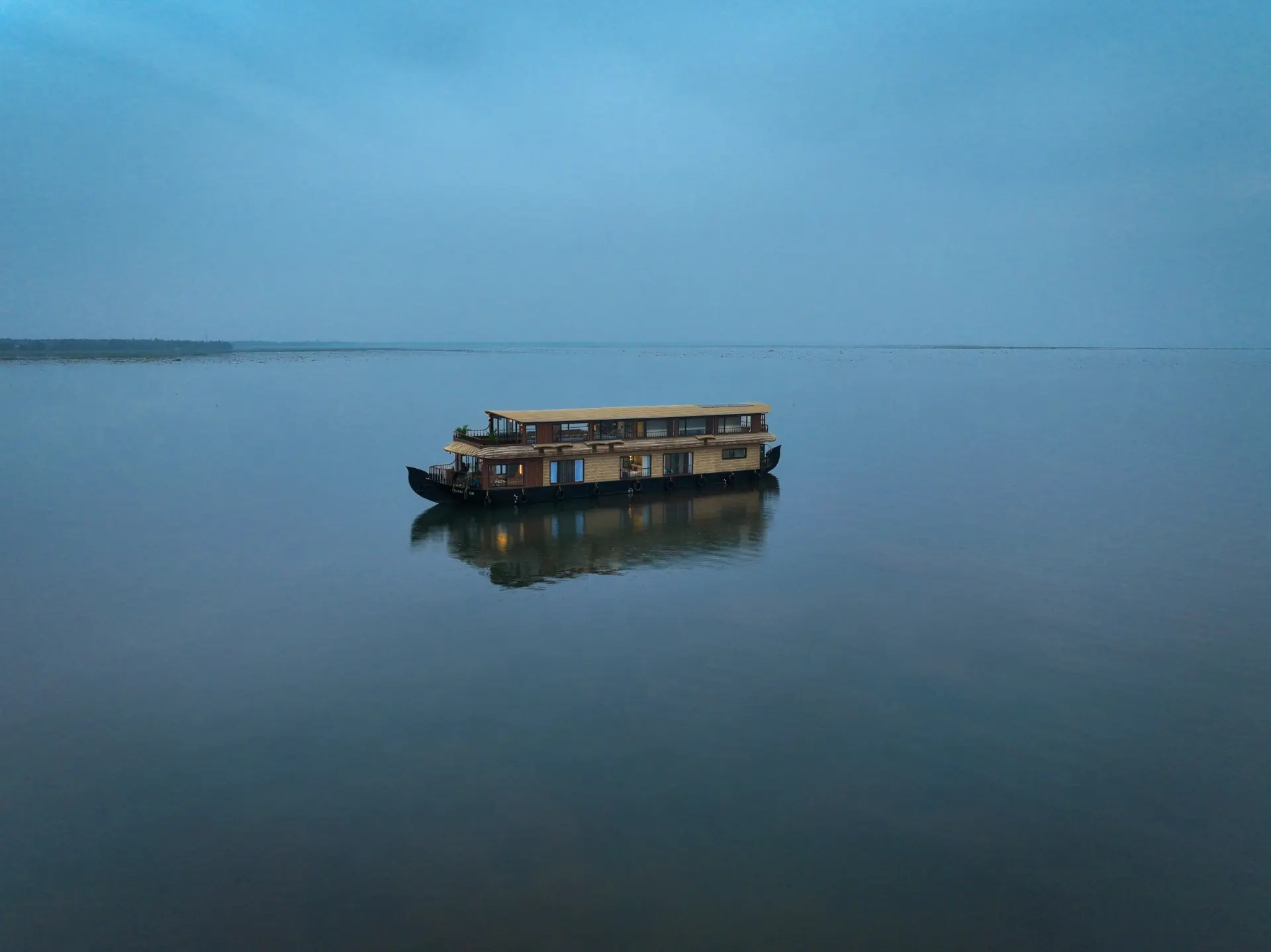 Kumarakom luxury houseboat on open water at blue hour
